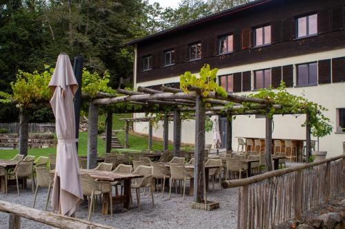 an outdoor patio with tables and chairs and an umbrella at Family & Mountain Lodge C'est la Vie in Hasliberg