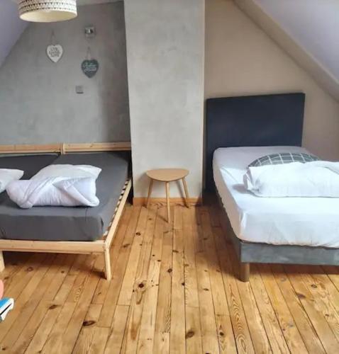 une chambre avec deux lits et un parquet dans l'établissement Gîte de vacances entre mer, campagne et forêt, à Neufchâtel-Hardelot