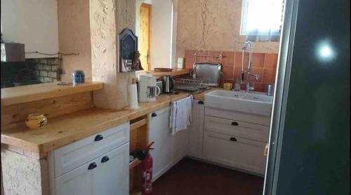 une cuisine avec un évier et un plan de travail dans l'établissement Mas Provençal 8 pers climatisé, 3 chambres avec salles de bains, piscine privée, à Évenos