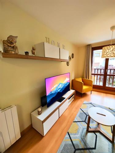 a living room with a flat screen tv on a wall at Apartamento Punta Escarra in Escarrilla