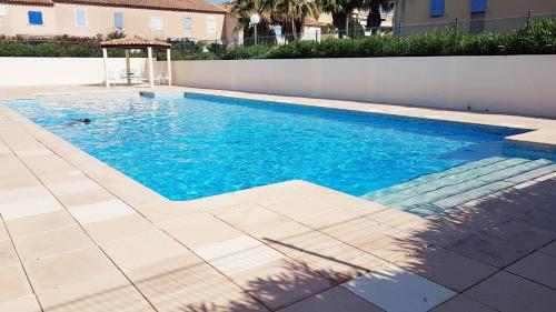- une piscine avec un kiosque à côté d'un mur dans l'établissement Résidence sécurisée avec piscine, T2 duplex, parking privé, climatisation, à La Seyne-sur-Mer