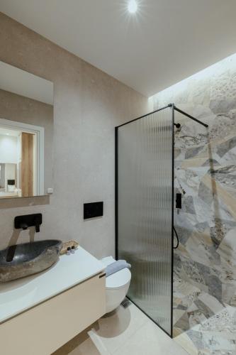 a bathroom with a sink and a shower at SEMIRAMIS Luxury Apartments in Poros