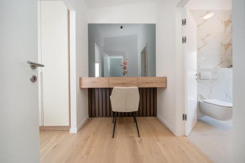 a bathroom with a vanity with a chair and a sink at NEW! Villa Adore Makarska in Makarska