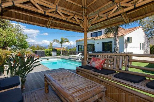 une terrasse avec une pergola en bois et une piscine dans l'établissement Villa piscine, climatisation, jardin, barbecue, internet, refait à neuf en 2023, à Six-Fours-les-Plages