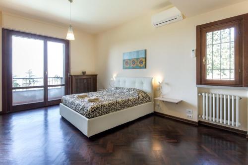 Un dormitorio con una cama y una ventana grande. en Villa Ballodole, en Florencia