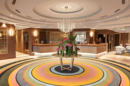 a lobby with a table with flowers on it at Hotel Leonardo da Vinci in Erba
