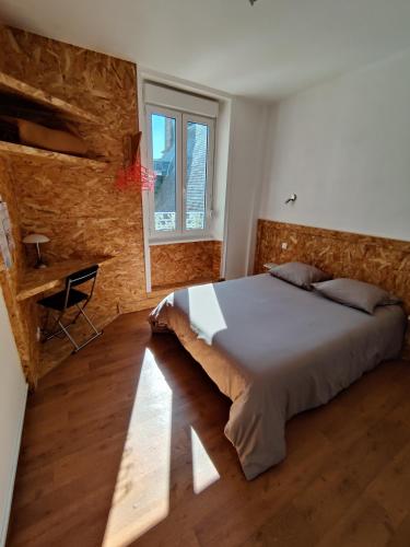 une chambre avec un grand lit et une fenêtre dans l'établissement Hôtel Saint - Pierre, à Villedieu-les-Poêles