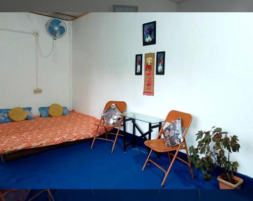 a room with a bed and a table and chairs at Garden View Homestay, Tinsukia in Tinsukia
