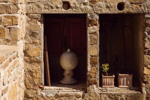 a stone wall with a vase in a window at Agriturismo Fattoria Poggio di Fiesole in Fiesole