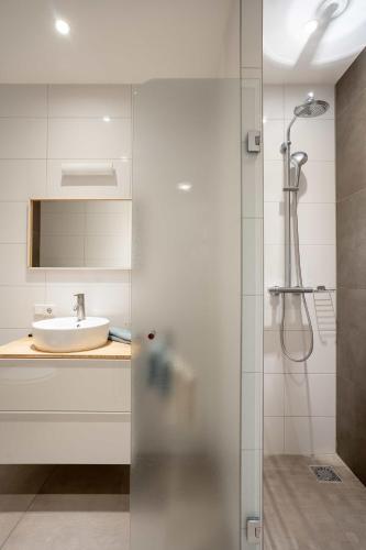 a bathroom with a shower and a sink at Hotel Bosch En Zee in Domburg