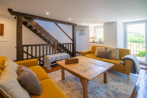a living room with yellow couches and a wooden table at Cal badia in Vilallovent