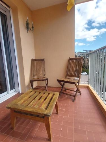 - deux chaises et un banc sur une terrasse couverte dans l'établissement Hello beachfront apartment, à Bandol