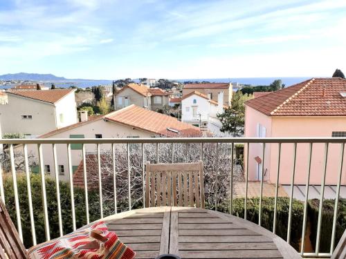 une chaise sur un balcon avec vue sur la ville dans l'établissement Hello beachfront apartment, à Bandol