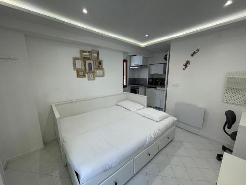 une chambre blanche avec un lit et une cuisine dans l'établissement Old town room 100m from beach, à Menton