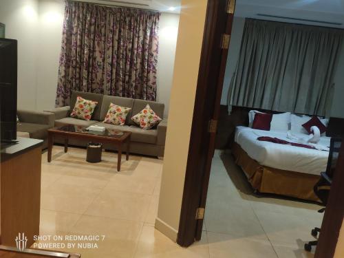 a hotel room with a bed and a couch at جولدن نيو حراء Golden New Hara- الشركة الذهبية العصرية الفندقية للشقق المخدومة in Jeddah