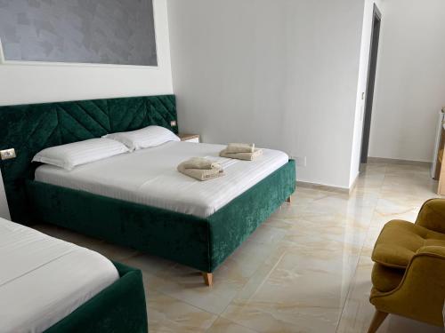 a bedroom with two beds and a chair at Hotel Leodori 1 in Shëngjin