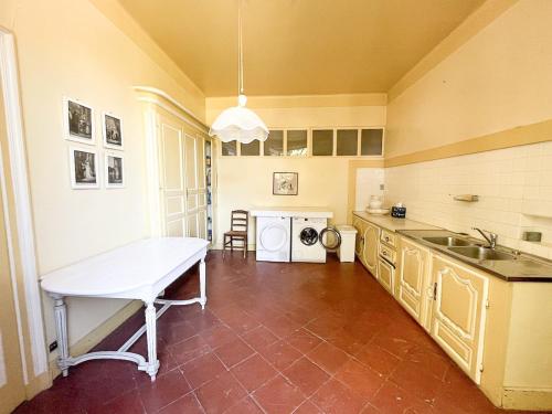 a kitchen with a table and a sink in it at Historic Manor With Pool In Quercy in Caussade