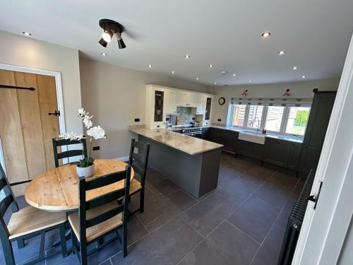 a kitchen and dining room with a wooden table at Fallow View - Luxury Countryside Cottage in Coughton
