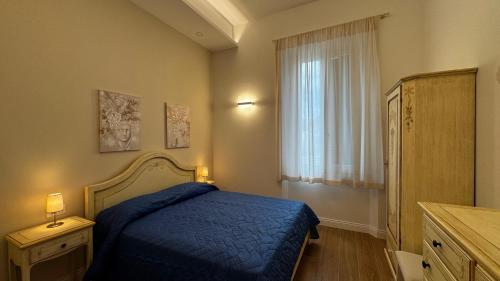 a bedroom with a blue bed and a window at Villa dei Limoni in San Vincenzo
