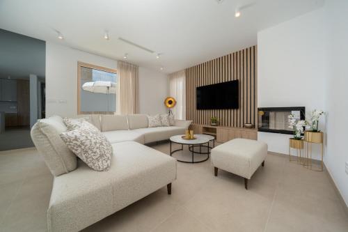 a living room with a couch and a tv at NEW! Villa Adore Makarska in Makarska