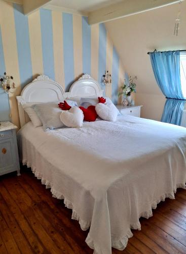 a white bed with two stuffed animals on it at Apartment Noorderloft in Hornhuizen