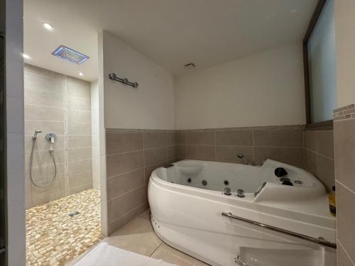 une salle de bain avec une baignoire blanche et une douche dans l'établissement VULMIX WE Grand appartement 13pers - Bourg St Maurice, à Bourg-Saint-Maurice