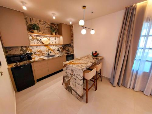 a kitchen with a counter and a table with chairs at Minares Luxury Suite in Rethymno Town