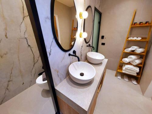 a bathroom with two sinks and a mirror and towels at Minares Luxury Suite in Rethymno Town