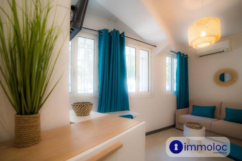 - un salon avec des rideaux bleus et un canapé dans l'établissement Air-conditioned studio in Fabron, à Nice