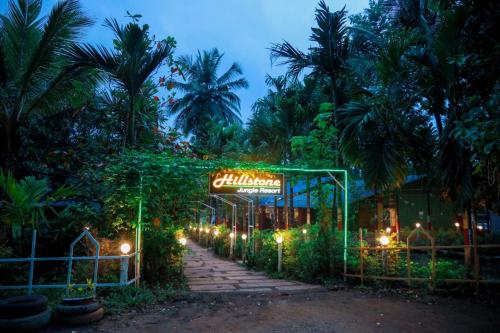 a sign for a garden at night with lights at River view adventures in Dandeli