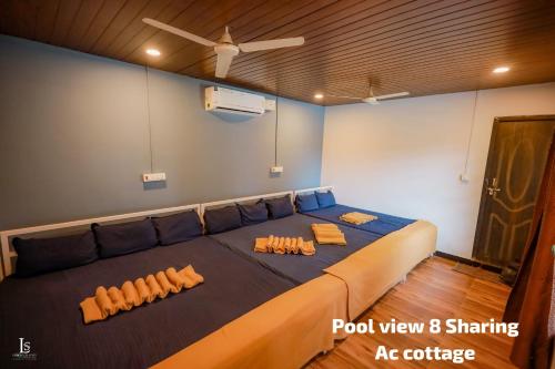 a large bed in a room with orange pillows on it at River view adventures in Dandeli