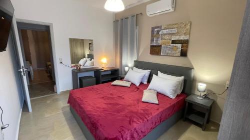 a bedroom with a red bed with white pillows at Katerina s House 1 in Nydri