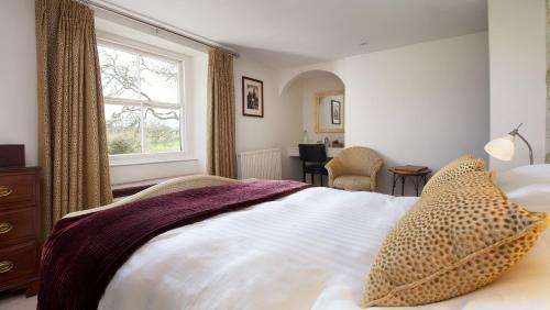 a bedroom with a large bed and a window at Mill End Hotel in Chagford