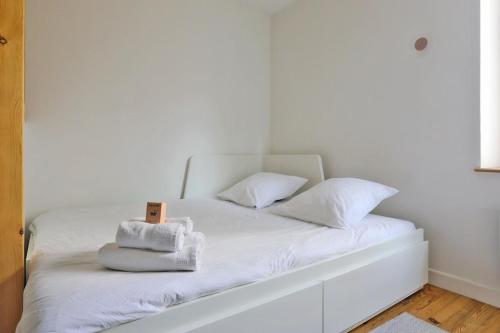 un lit blanc avec des serviettes dessus dans l'établissement Le Olry - Studio 2 personnes - Terrasse - Cosy, à Nancy