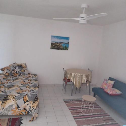 a room with a bed and a table and a couch at Appartement Labrousse - POM KANEL in Le Gosier
