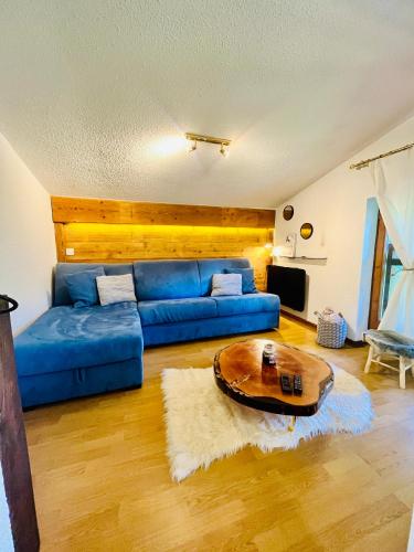 un salon avec un canapé bleu et une table dans l'établissement Elegant et cosy, Appt à la montagne, à Combloux