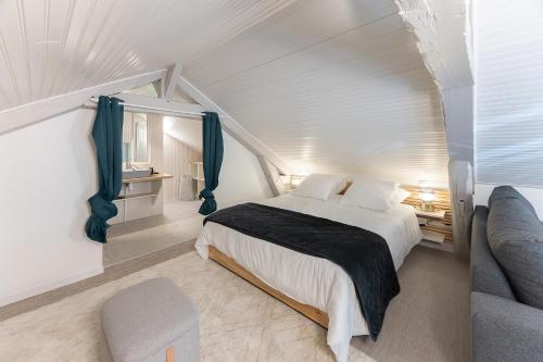 une chambre blanche avec un lit et une chaise dans l'établissement Gîte du Cordon de Loire, à Jargeau