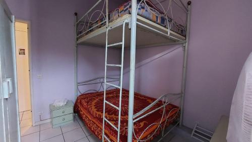 une chambre avec un lit superposé avec un couvre-lit rouge dans l'établissement PASTEL T2 loggia 100m de la plage, à Leucate-Plage