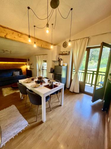 un salon avec une table et des chaises blanches dans l'établissement Elegant et cosy, Appt à la montagne, à Combloux