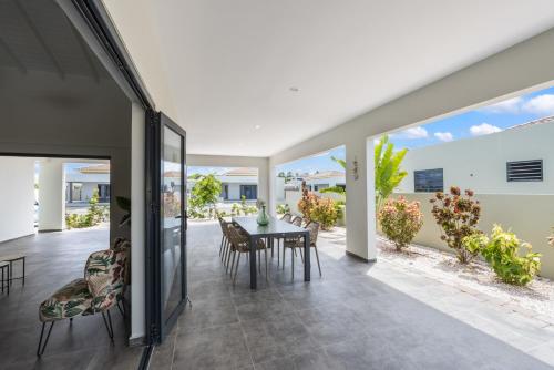 an open living room with a table and chairs at Villa Jasmijn met privezwembad, Mambo Beach in Willemstad