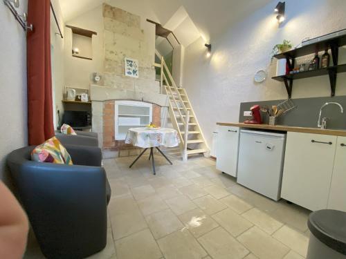 Il comprend une cuisine et un salon avec une table et des escaliers. dans l'établissement Domaine de la Closerie Champêtre, à Huismes