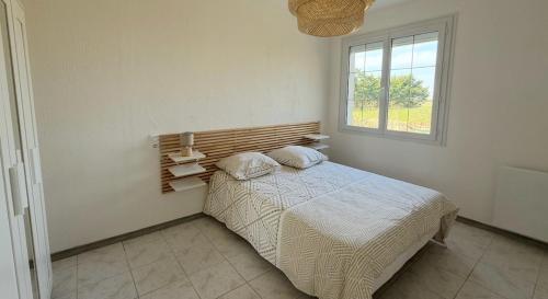 une chambre avec un lit et une fenêtre dans l'établissement L'échappée, à Bouin