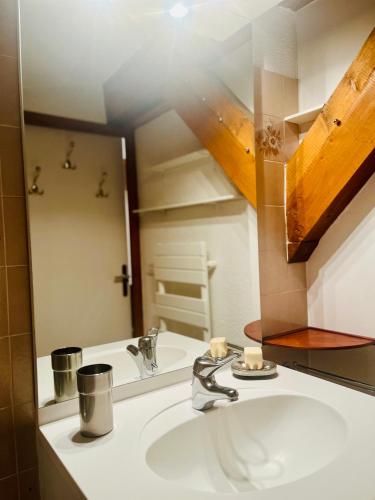 une salle de bain avec un lavabo et un miroir dans l'établissement Elegant et cosy, Appt à la montagne, à Combloux