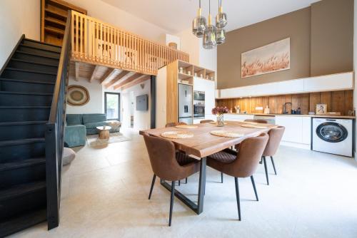 une cuisine et une salle à manger avec une table et des chaises en bois dans l'établissement Maisons PontCanal, 2 villas réunies au bord du canal à Cazaux, à La Teste-de-Buch