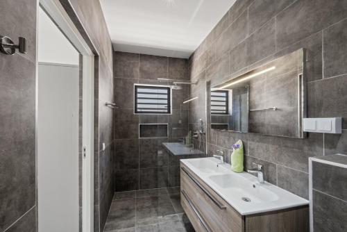 a bathroom with a sink and a mirror at Villa Jasmijn met privezwembad, Mambo Beach in Willemstad
