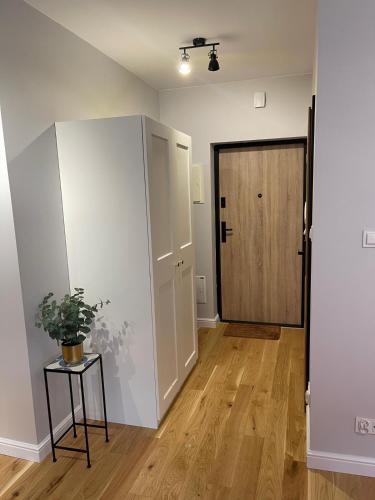 an empty room with a door and a potted plant at GREY PEPPER with balcony in Siedlce
