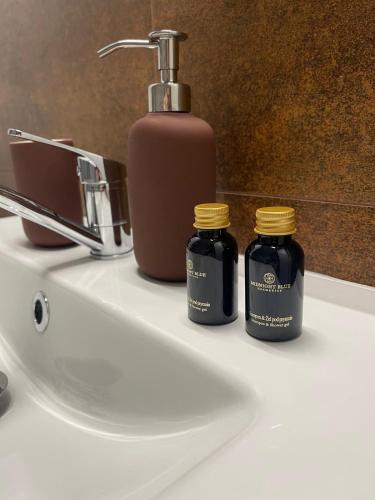 two jars sitting on a bathroom sink with a faucet at GREY PEPPER with balcony in Siedlce