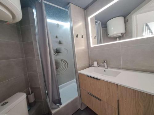 une salle de bain avec un lavabo, une douche et un miroir dans l'établissement Appart 2 pièces mezzanine clim, bord de plage, parking - FR-1-326-722, à Marseillan