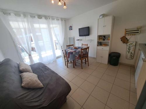 - un salon avec un lit et une table à manger dans l'établissement Appartement avec Terrasse, Accès Direct Plage et Piscine à Marseillan - FR-1-326-762, à Marseillan