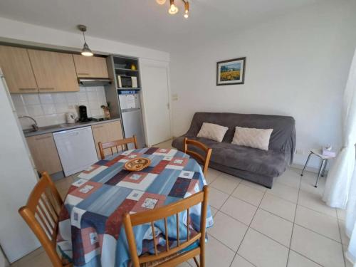 une cuisine et un salon avec une table et un canapé dans l'établissement Appartement avec Terrasse, Accès Direct Plage et Piscine à Marseillan - FR-1-326-762, à Marseillan